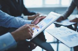 Image of businessperson pointing at document in touchpad at meeting