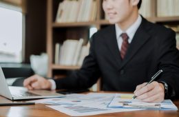 young businessman working with mobile laptop and documents in office, business concept